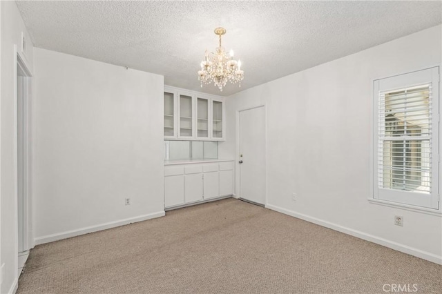 1620 S Cypress Ave, Ontario, CA 91762 - spare room with a chandelier, a textured ceiling, light colored carpet, and plenty of natural light