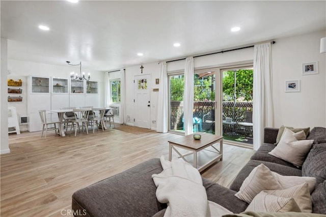 living area featuring recessed lighting, an inviting chandelier, and light wood-type flooring