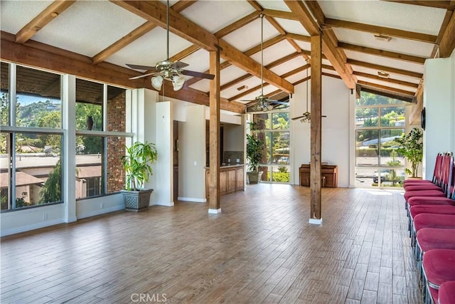 interior space featuring vaulted ceiling with beams, baseboards, ceiling fan, and wood finished floors