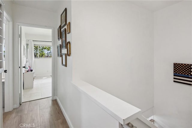 hallway with baseboards and wood finished floors