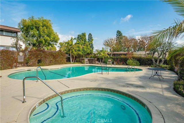 community pool featuring a patio and fence