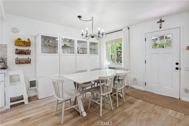 dining space featuring light wood-type flooring, baseboards, a notable chandelier, and visible vents