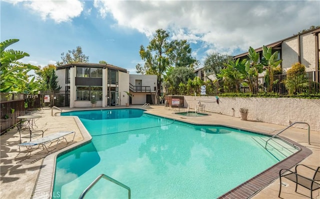 pool with a patio and fence