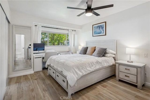 bedroom with a ceiling fan, baseboards, and light wood finished floors