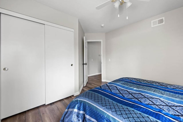 bedroom with visible vents, a closet, wood finished floors, baseboards, and ceiling fan