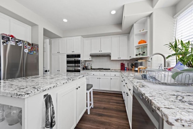 kitchen with open shelves, decorative backsplash, white cabinetry, dark wood finished floors, and stainless steel appliances