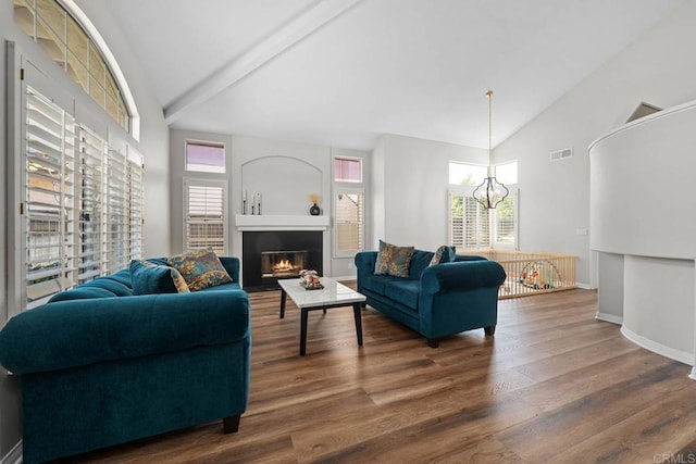 living room featuring high vaulted ceiling, a chandelier, wood finished floors, and visible vents