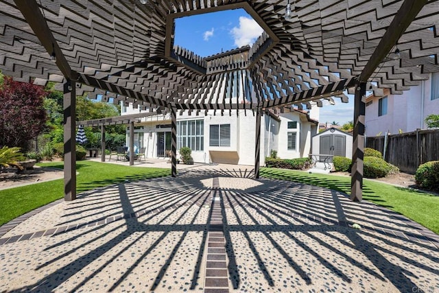 view of patio featuring fence, a pergola, an outdoor structure, and a shed