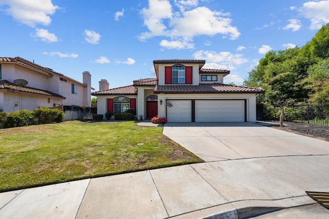 mediterranean / spanish home with concrete driveway, fence, a tile roof, and a front yard