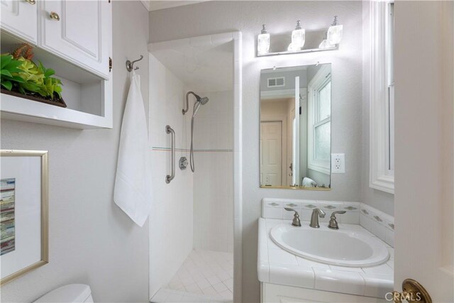 full bath with a tile shower, toilet, and vanity