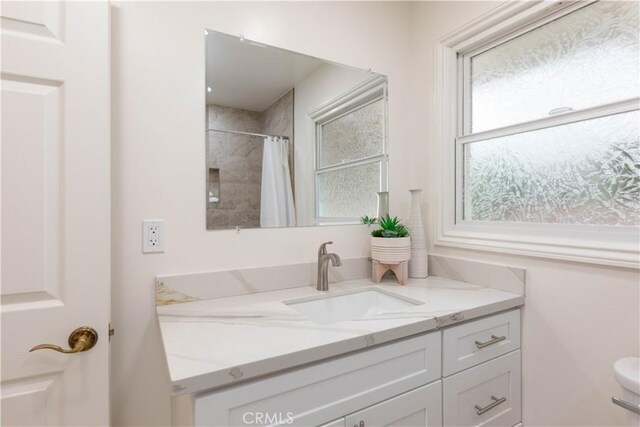 full bathroom featuring vanity, a shower with shower curtain, and toilet