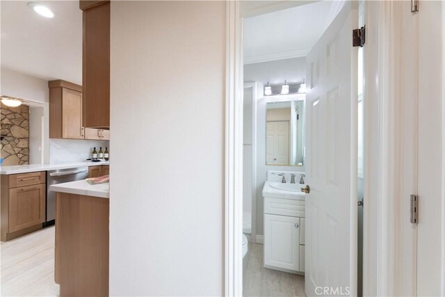hall with a sink and ornamental molding