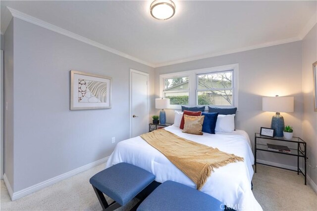 bedroom featuring baseboards, ornamental molding, and carpet flooring