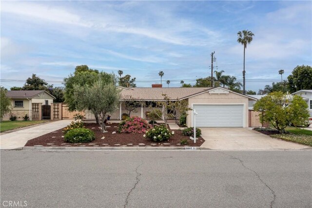 ranch-style home with concrete driveway, fence, and a garage