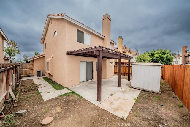 back of property featuring a pergola, stucco siding, a patio area, and a storage shed
