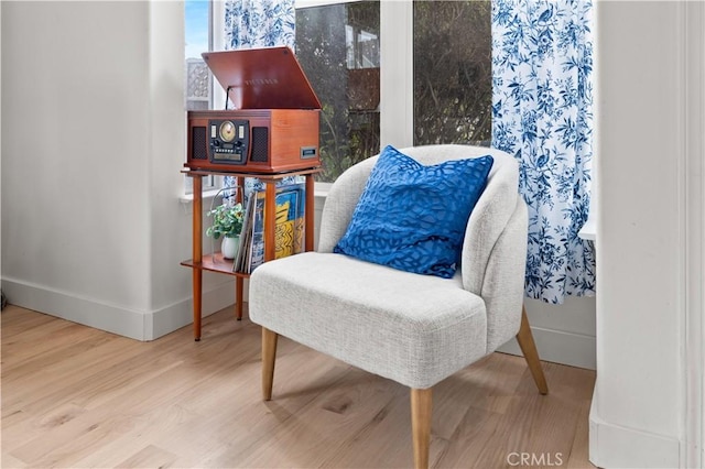living area with baseboards and wood finished floors