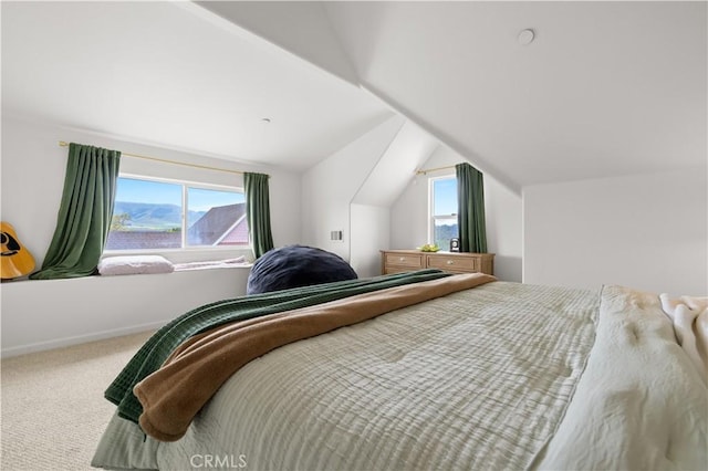 carpeted bedroom with baseboards, lofted ceiling, and multiple windows
