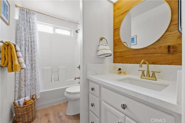 bathroom featuring vanity, wood finished floors, toilet, and shower / bath combo with shower curtain