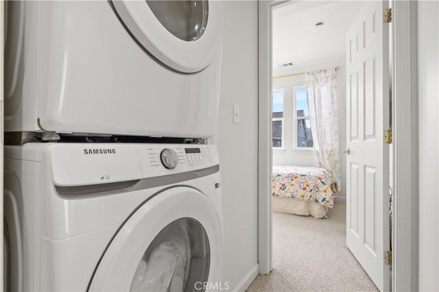 laundry room with stacked washer / drying machine, light colored carpet, laundry area, baseboards, and visible vents