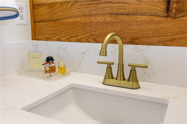 interior details featuring decorative backsplash and a sink