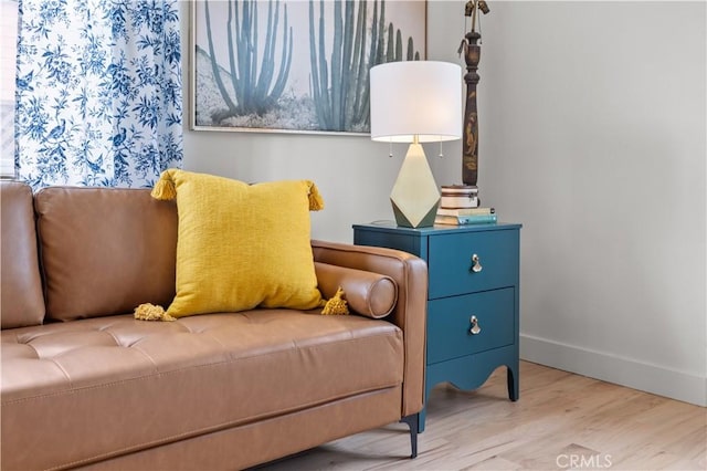 living area with baseboards and wood finished floors