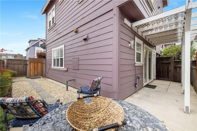 view of home's exterior with a fenced backyard, a gate, a patio, and a pergola