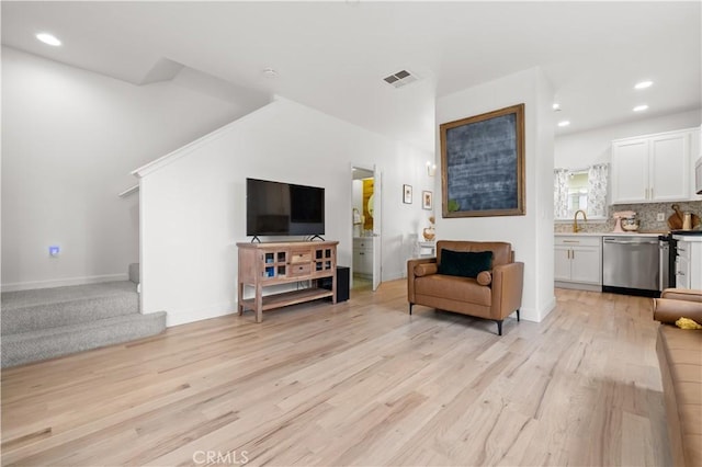 living area with recessed lighting, baseboards, visible vents, and light wood-type flooring