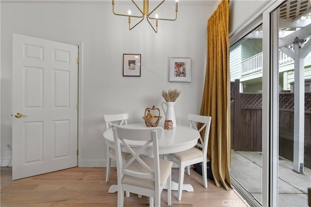 dining space featuring light wood-style floors and a notable chandelier