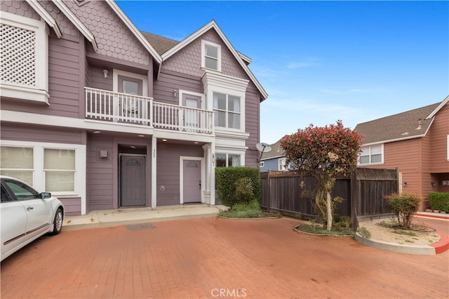 townhome / multi-family property featuring fence and a balcony