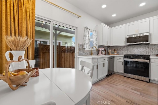 kitchen featuring a sink, appliances with stainless steel finishes, decorative backsplash, and recessed lighting