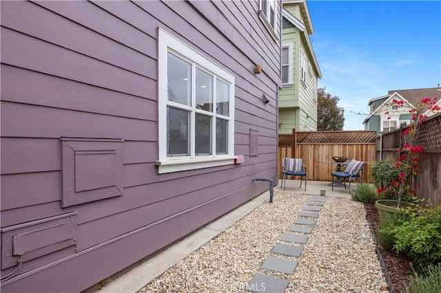 view of side of property with a patio and fence