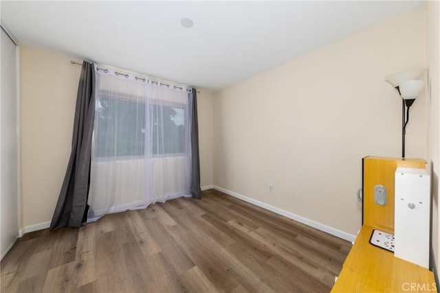empty room featuring baseboards and wood finished floors