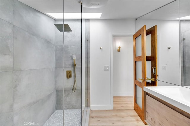 bathroom featuring vanity, wood finished floors, and a shower stall