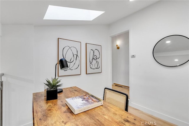 dining room with recessed lighting, a skylight, baseboards, and wood finished floors