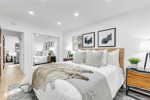 bedroom featuring recessed lighting, wood finished floors, and a closet