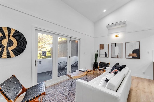 living area featuring a wall mounted air conditioner, high vaulted ceiling, recessed lighting, french doors, and light wood-style flooring