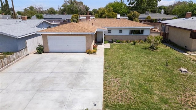 single story home with a front lawn, an attached garage, fence, and concrete driveway