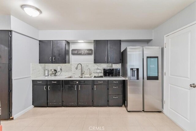 44650 2nd St E, Lancaster, CA 93535 - kitchen featuring stainless steel refrigerator with ice dispenser, a sink, black microwave, light countertops, and backsplash