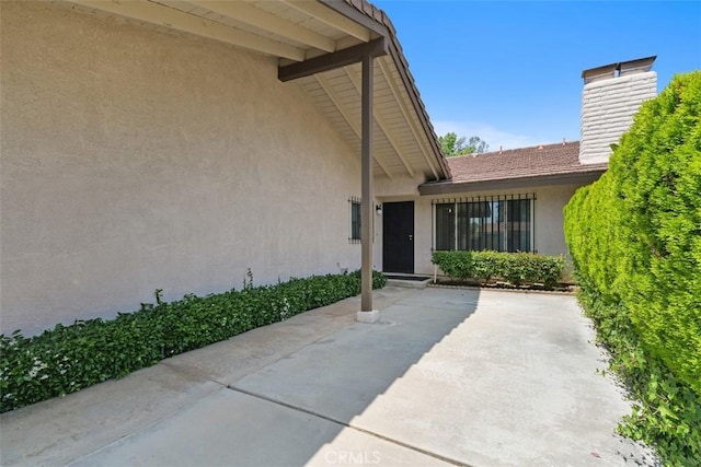 2797 Persimmon Pl, Riverside, CA 92506 - doorway to property with a chimney, a patio area, and stucco siding