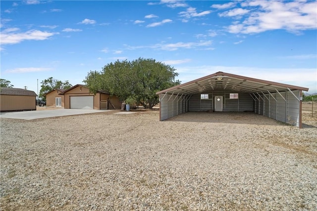 exterior space with a carport, an outdoor structure, and gravel driveway