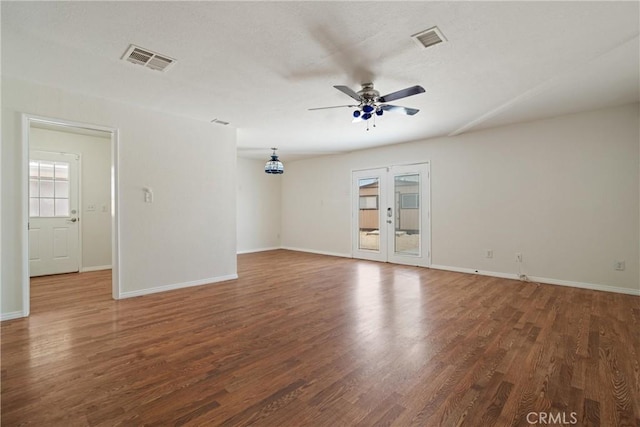 unfurnished room featuring baseboards, ceiling fan, wood finished floors, and visible vents