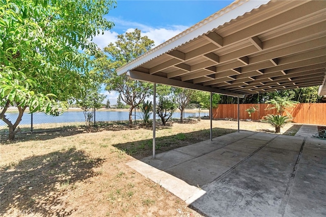 view of patio / terrace featuring a water view and a fenced backyard