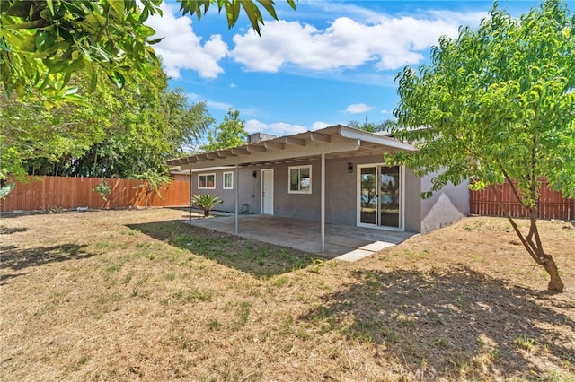 rear view of property with stucco siding and a patio