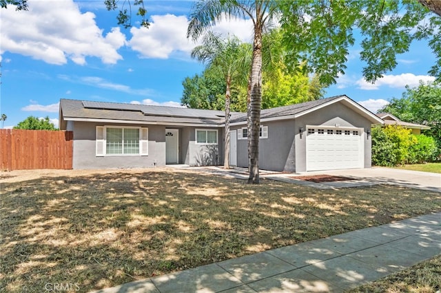 single story home featuring a garage, driveway, stucco siding, and roof mounted solar panels