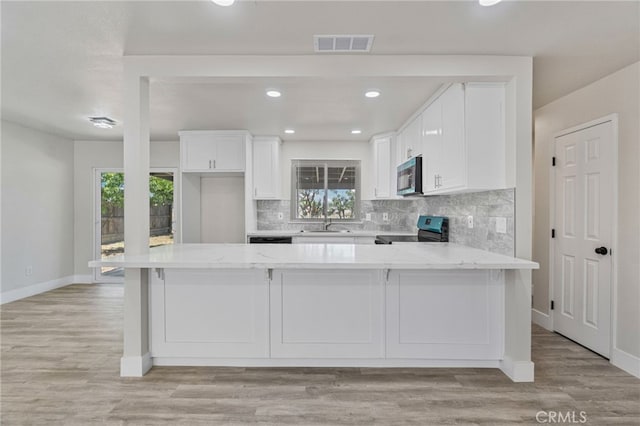 kitchen with stainless steel appliances, a sink, white cabinetry, baseboards, and recessed lighting