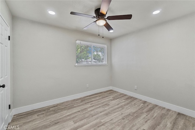 spare room featuring light wood-type flooring, a ceiling fan, baseboards, and recessed lighting
