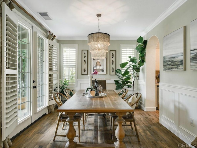 dining space featuring visible vents, dark wood finished floors, a decorative wall, and a chandelier