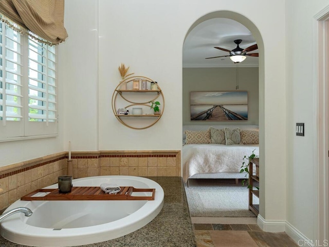 bathroom with ceiling fan, ornamental molding, and a bath