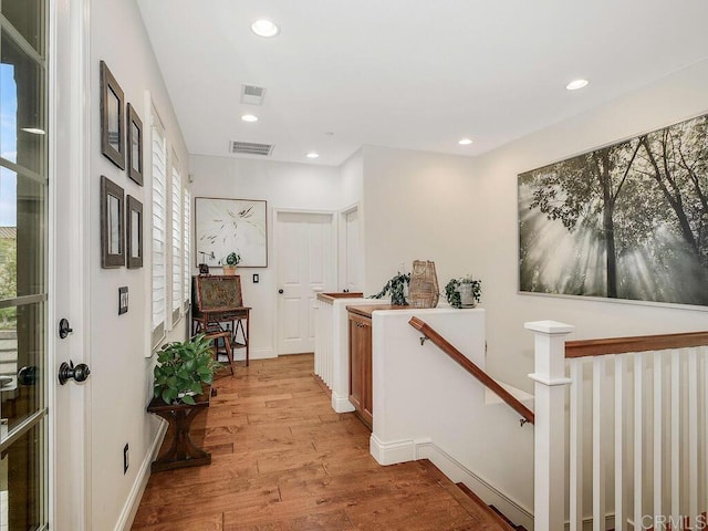 hallway featuring recessed lighting, an upstairs landing, light wood finished floors, and visible vents