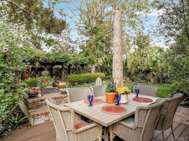 wooden deck featuring outdoor dining area, a patio area, and fence